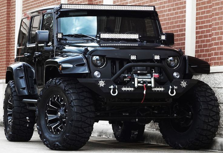 a black jeep parked in front of a brick building