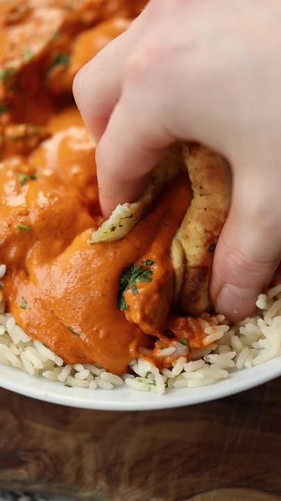 someone is dipping some kind of sauce on top of rice in a bowl with chicken