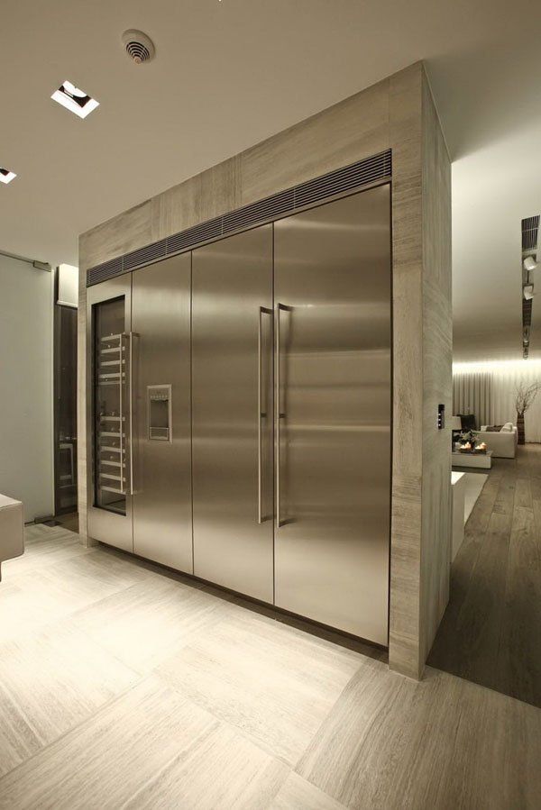 a stainless steel refrigerator in the middle of a room