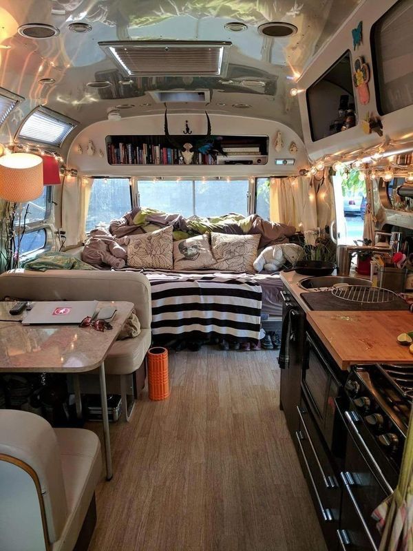 the inside of a camper with lots of furniture and decor on it's walls