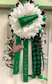 a green and white wreath hanging on the front door with ribbon around it that says go team