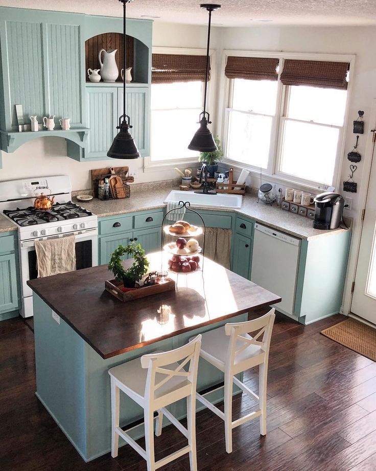 a kitchen with blue cabinets and wooden floors is pictured in this image, there are three chairs at the center of the island