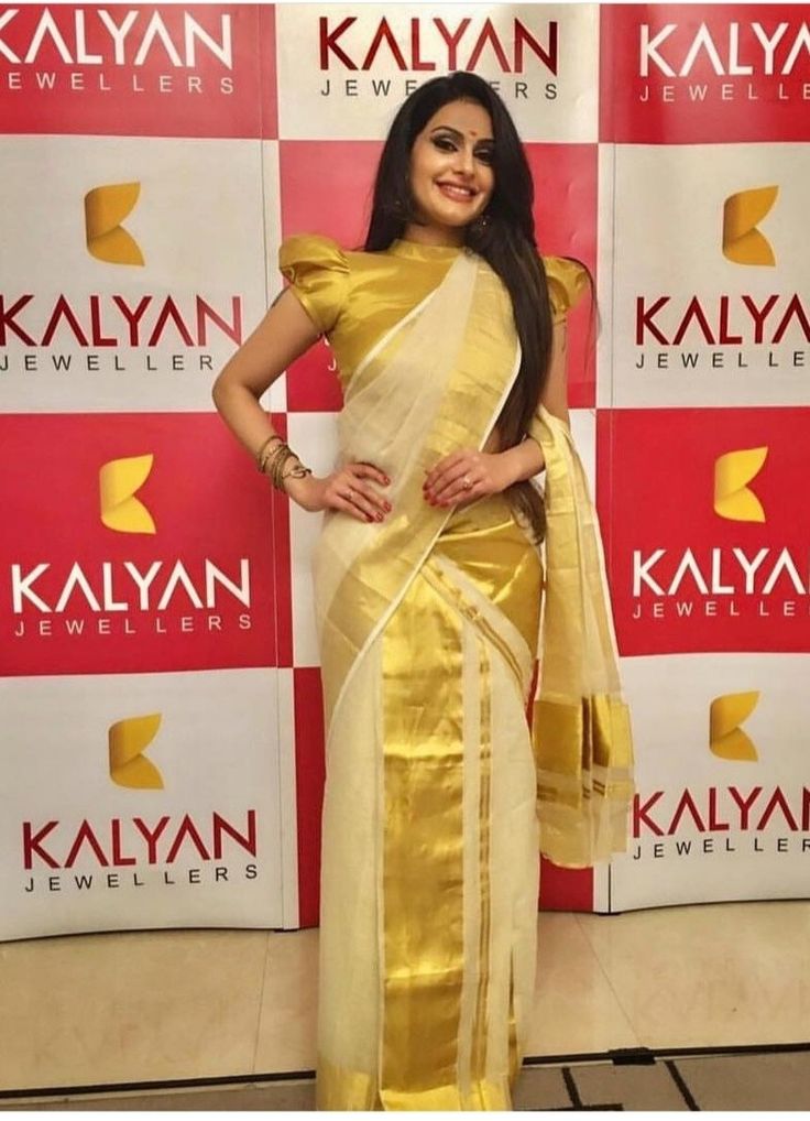 a woman in a yellow sari posing for the camera