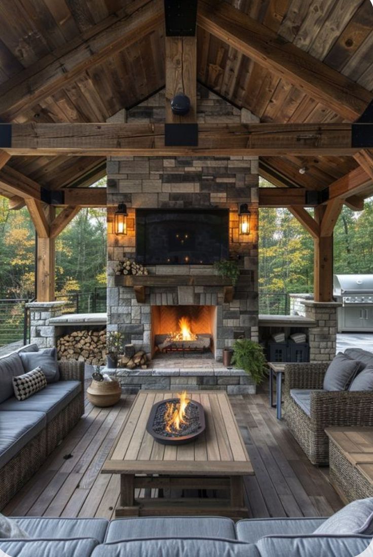 an outdoor living area with couches, tables and a fire place in the center