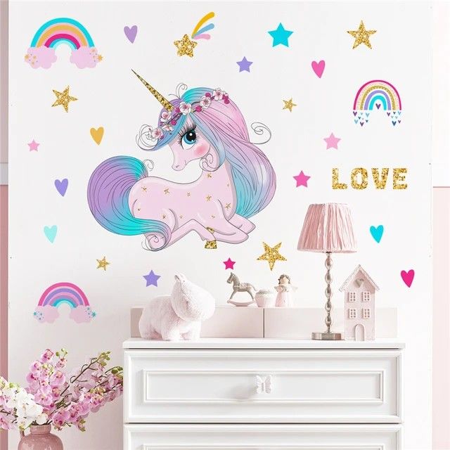 a white dresser sitting next to a wall with a pink unicorn on top of it