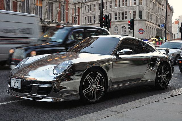 a silver sports car driving down the street