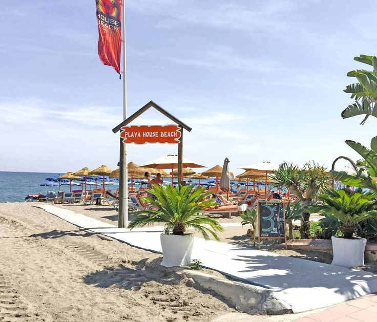 the beach is lined with umbrellas and palm trees