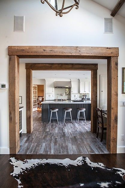 an open kitchen and dining room with wood flooring in the living room, along with a cow hide rug on the hardwood floor