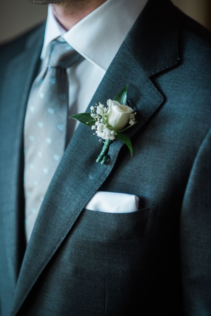 a man in a suit and tie with a boutonniere on his lapel