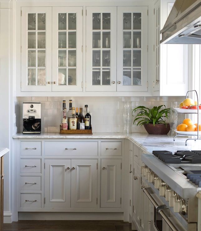 a kitchen with white cabinets and wooden counter tops