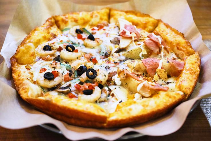 a pizza sitting on top of a wooden table