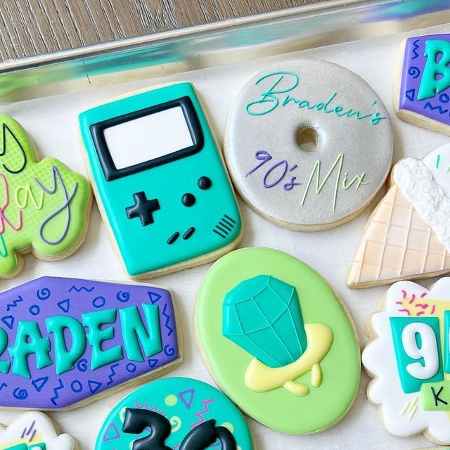 decorated cookies in the shape of cell phones and doughnuts with writing on them