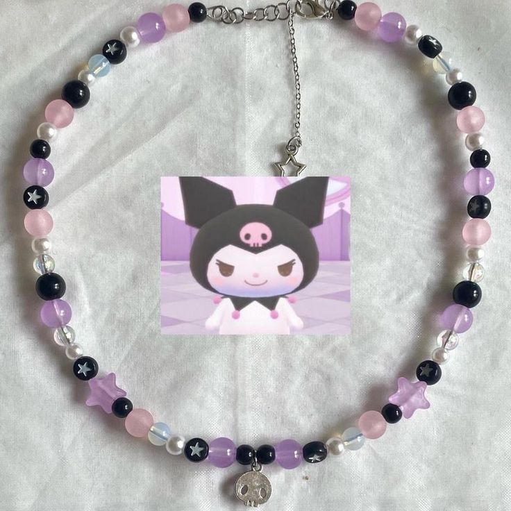 a necklace with an image of a cat on the front and purple beads around it