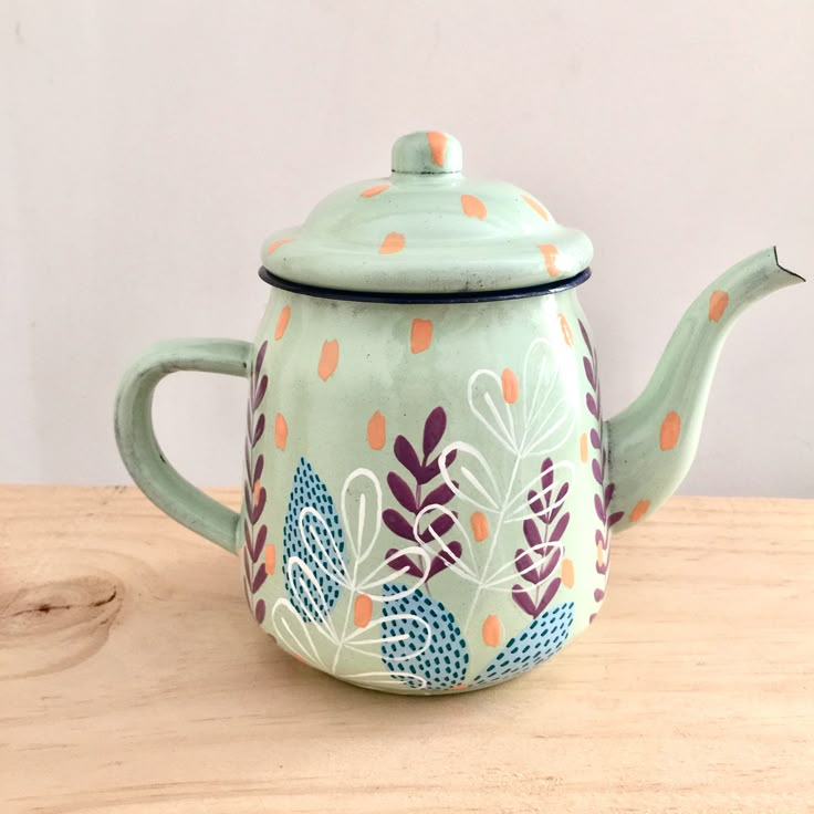 a ceramic teapot sitting on top of a wooden table