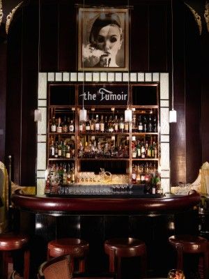 a bar with lots of liquor bottles and stools