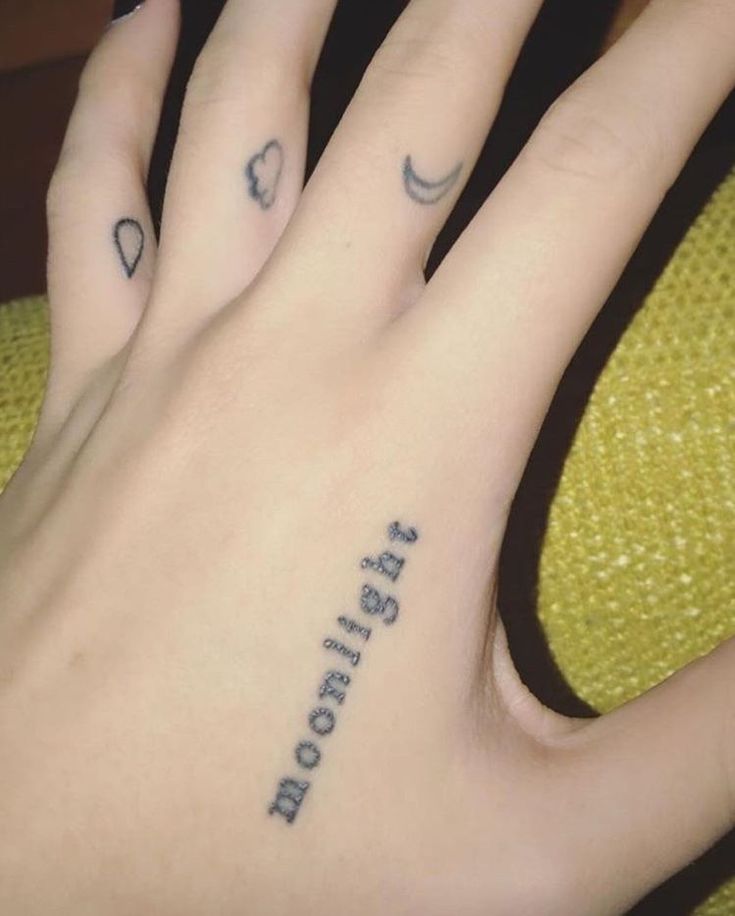 a person's left hand with two small tattoos on it and the words sister written in cursive font