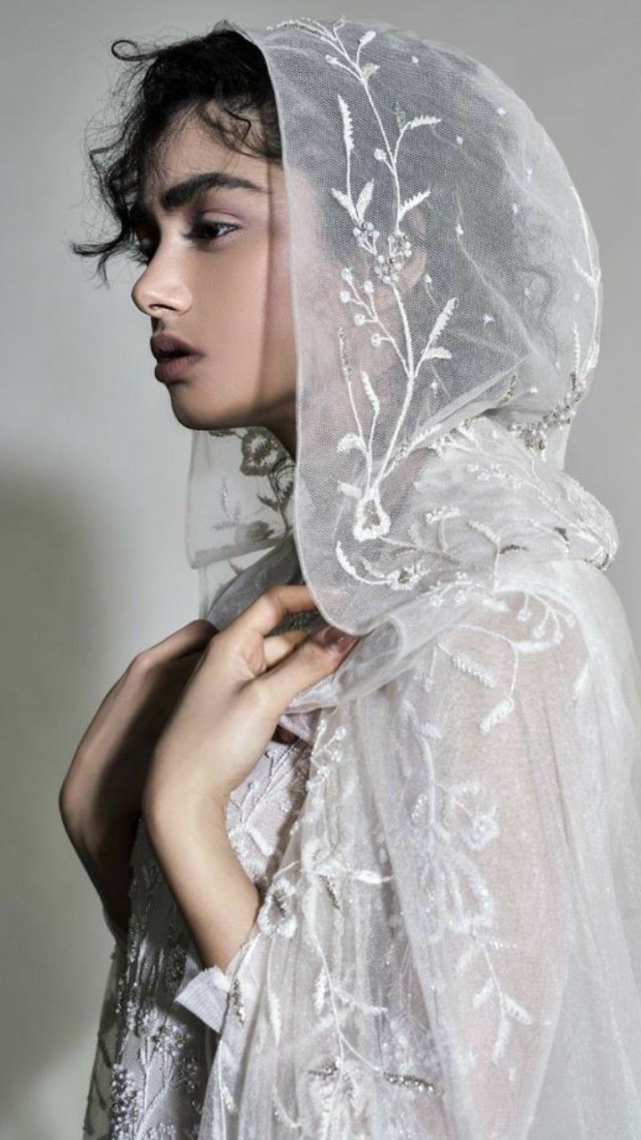 a woman wearing a veil with flowers on it