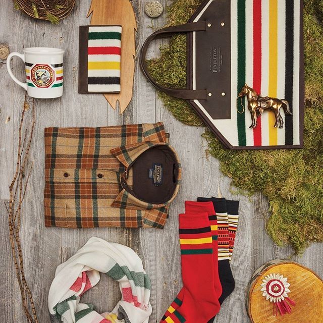 various items are laid out on a wooden surface, including socks, scarves and purses