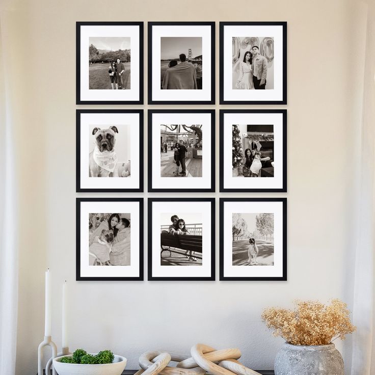 black and white photographs are hung on the wall above a table with bread, vegetables and fruit