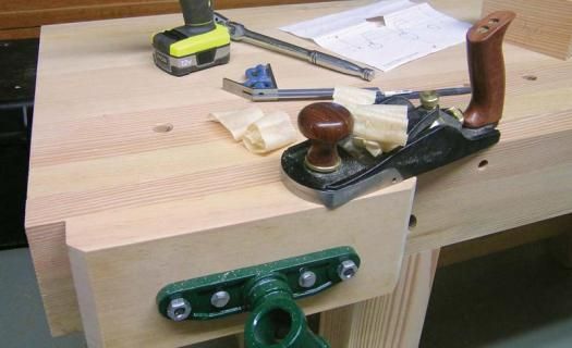 a workbench with some tools on it sitting on top of a wooden table