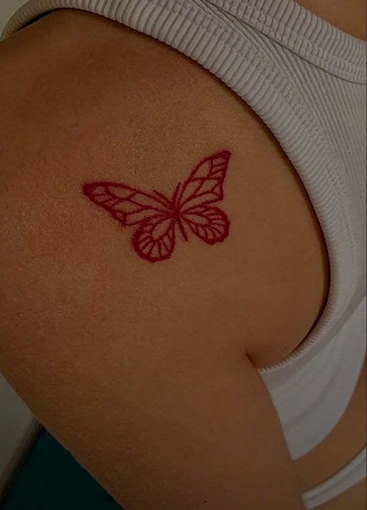 a butterfly tattoo on the back of a woman's left upper arm and shoulder