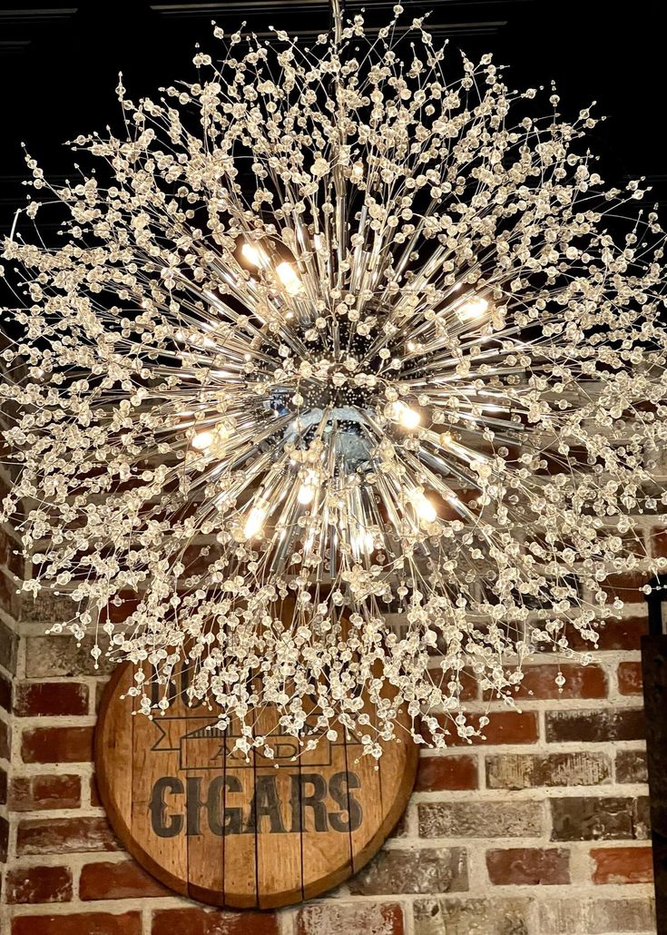 a chandelier hanging from the side of a brick wall next to a sign