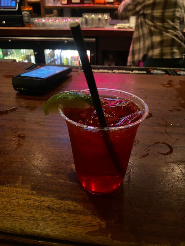 a red drink sitting on top of a wooden table