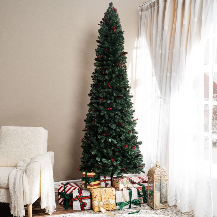 a christmas tree with presents under it in front of a window