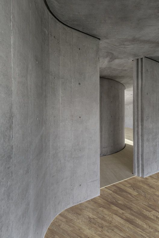 an empty room with concrete walls and wooden floors is seen in this image from the inside