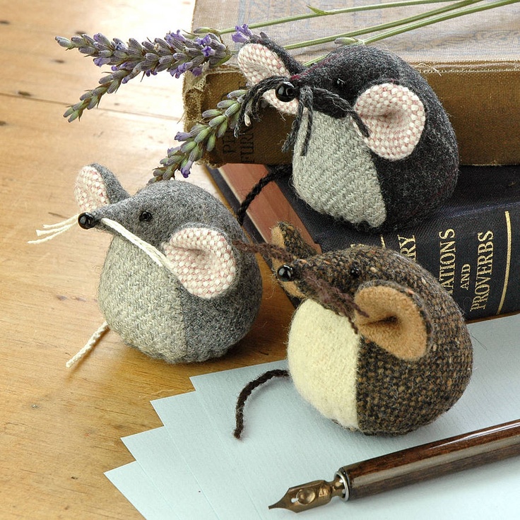 two stuffed mice sitting on top of books next to a pen and flower potted plant