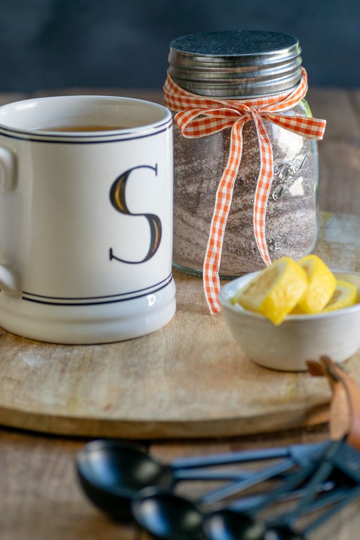 a mason jar filled with lemons next to a bowl of sugar