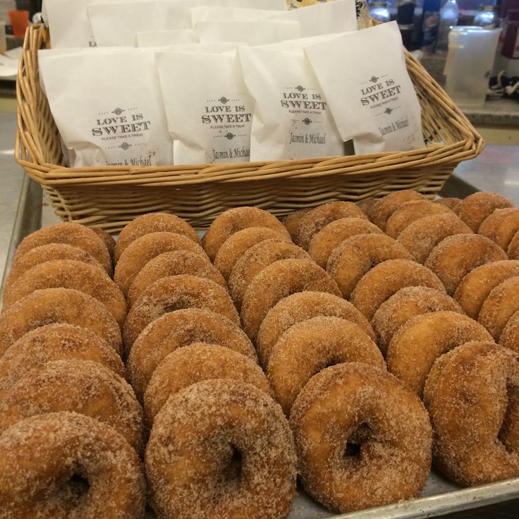 donuts and coffee bags are on display in a bakery basket next to other pastries