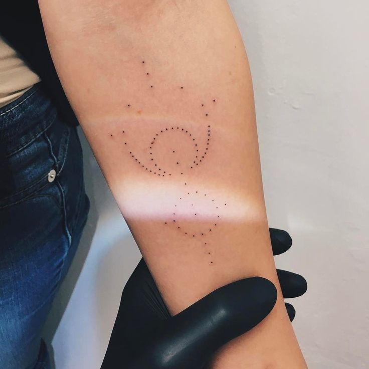 a woman's arm with dots on it and the word love written in cursive writing