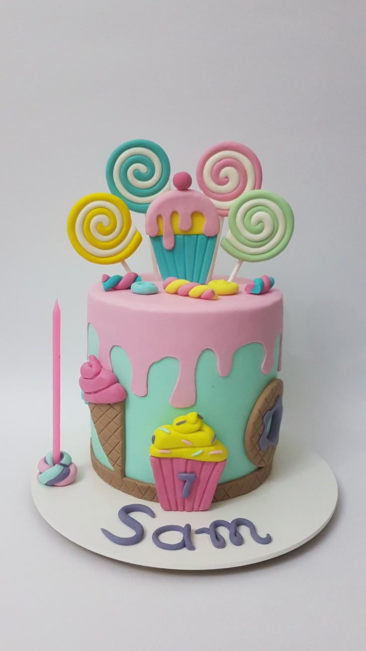 a birthday cake decorated with candy, lollipops and swirly candies