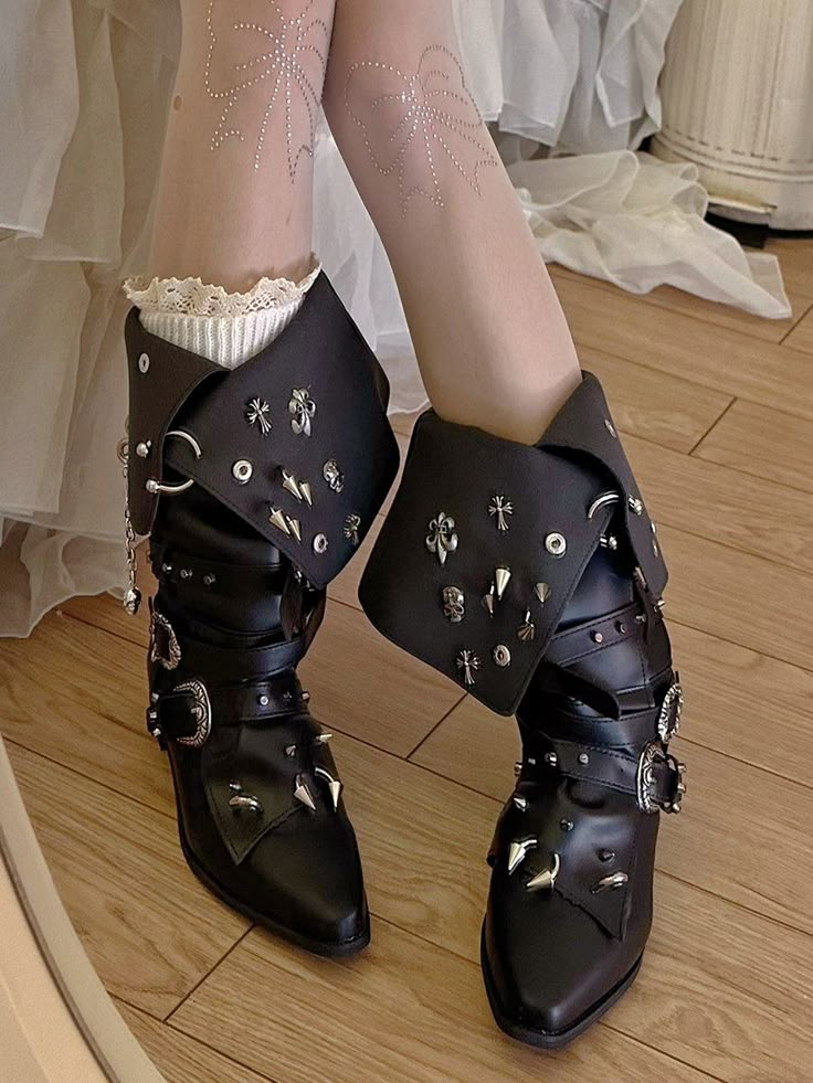 Step into a world of gothic elegance with these striking pointed-toe boots. Featuring a unique fold-over design adorned with skeleton and cross stud embellishments, these boots are a true statement piece. The addition of chain decorations adds an edgy flair, while the upper is further enhanced with stud details. For a personalized fit and style, adjustable buckle straps are included, ensuring both comfort and a perfect fit. Embrace your dark side with these intricately designed boots that blend Goth Lace Up Boots, Trad Goth Shoes, Gothic Ballerina, Fantasy Boots, Gothic Heels, Chain Decorations, Armor Boots, Embrace Your Dark Side, Gothic Elegance