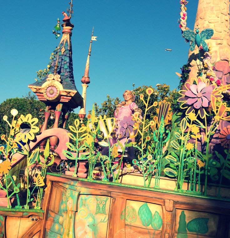 an elaborately decorated float in the shape of a flower garden with people on it