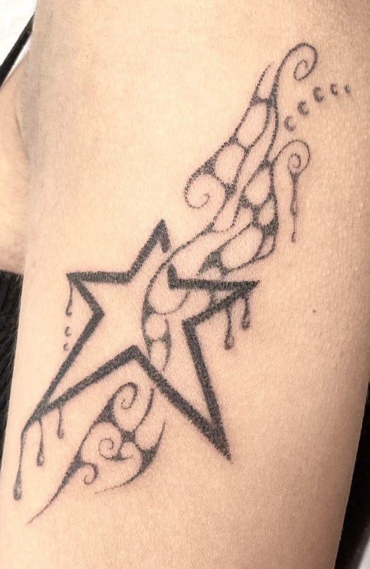 a black and white photo of a star tattoo on the side of a woman's thigh