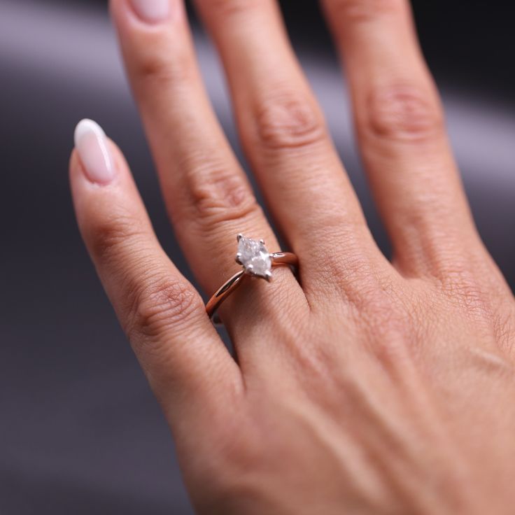 a woman's hand with a diamond ring on it