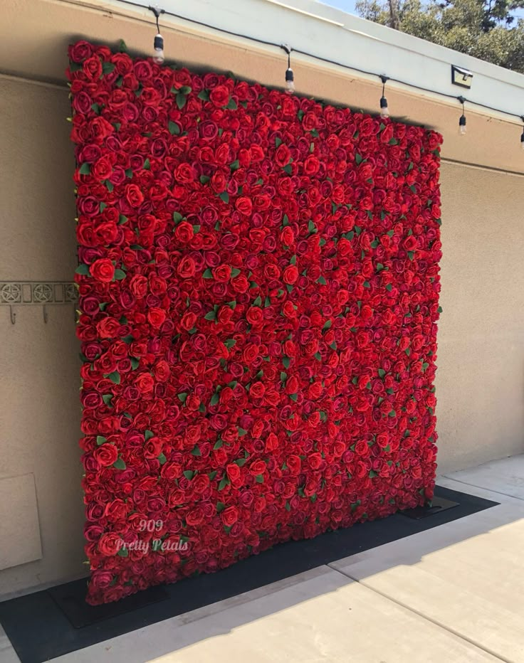 a large red flowered wall on the side of a building