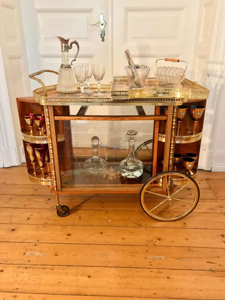 an antique brass bar cart with glass shelves