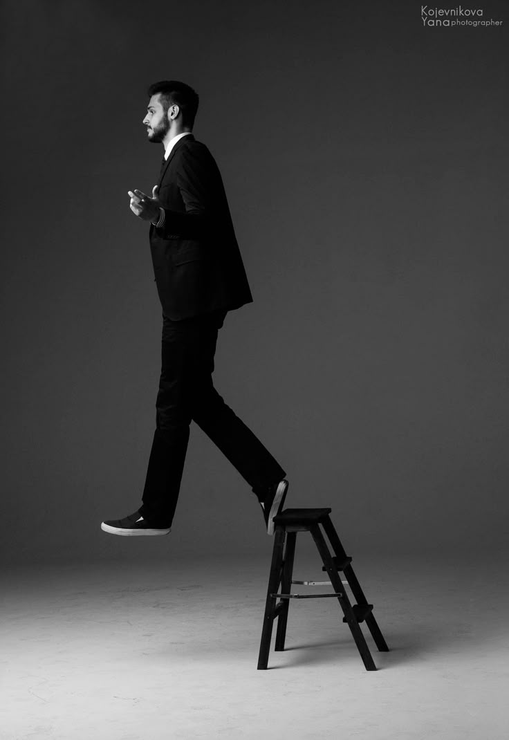 a man in a suit is walking on a step stool