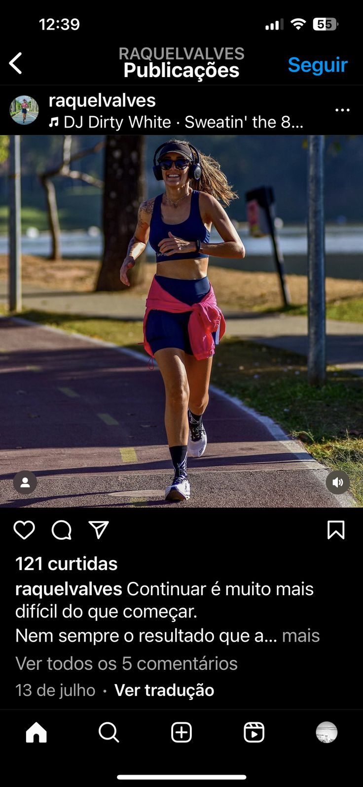 a woman running down a street next to a tree