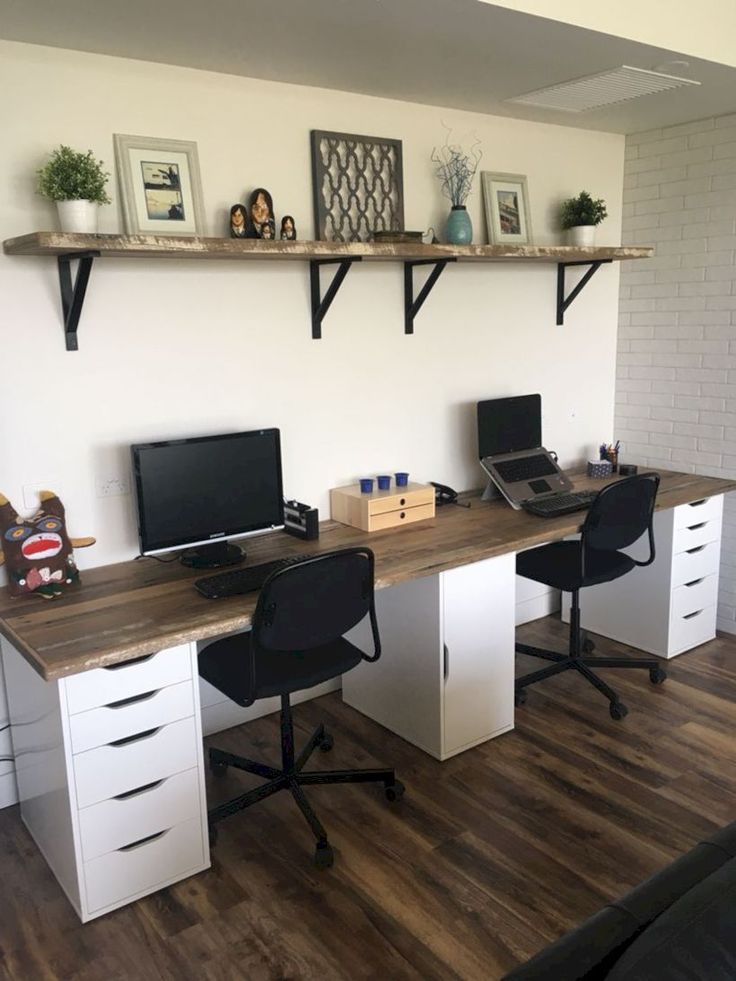 an office with two desks and three computer screens on the wall above them is shown