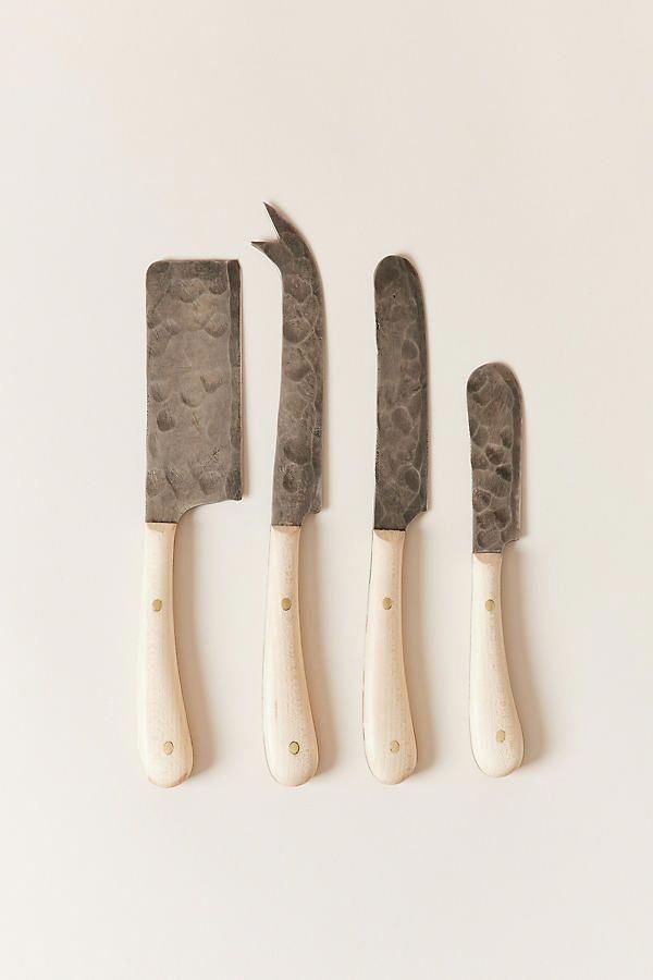 four knives and a spatula on a white surface