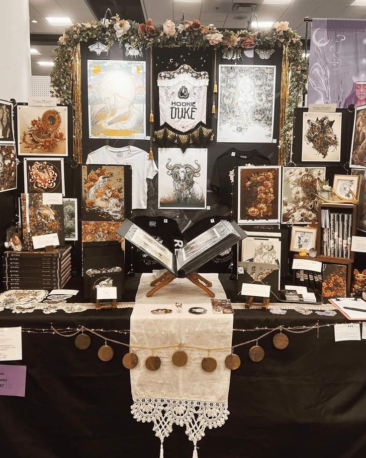 a table with pictures and cards on it in front of a black cloth covered wall