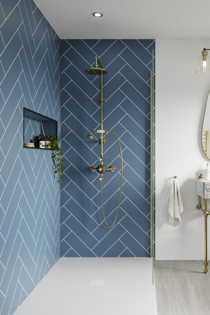 a bathroom with blue and white tiles on the wall, gold fixtures and a shower head