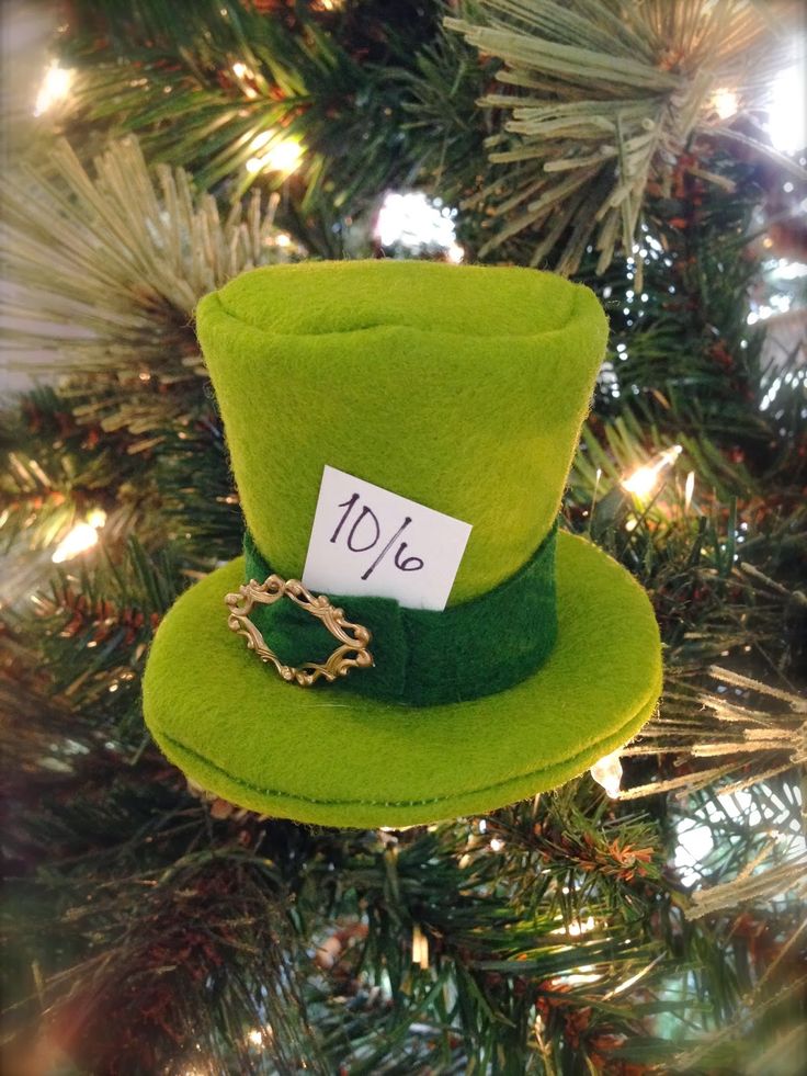 a green hat ornament hanging from a christmas tree with a sale tag on it