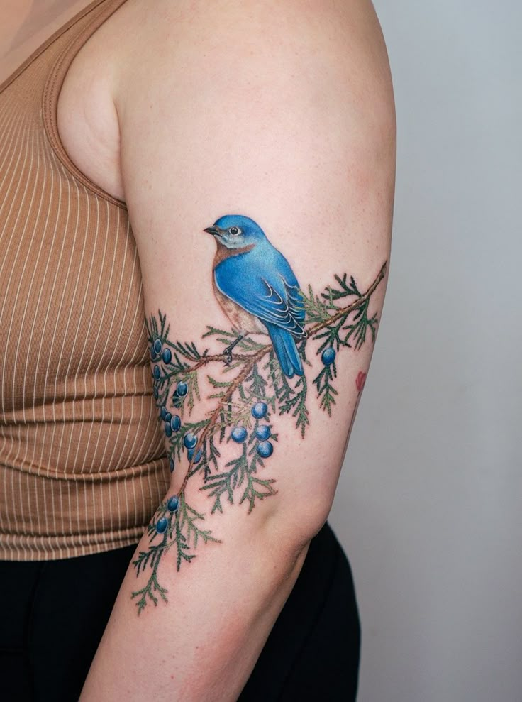 a woman with a blue bird tattoo on her arm