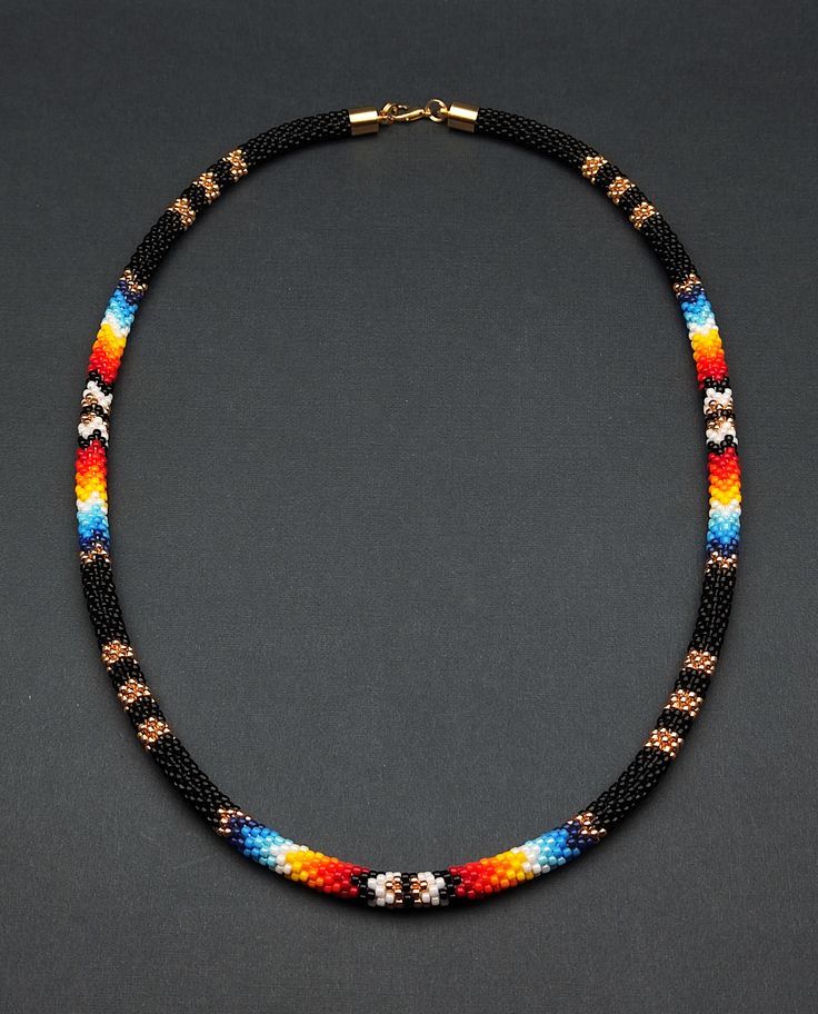 Add a touch of cultural flair with this ethnic beaded choker necklace. Inspired by Native American traditions, the intricate beadwork and unique design make it a standout piece of jewelry. Artisan Black Beaded Necklace Handwoven, Artisan Black Handwoven Beaded Necklace, Artisan Handwoven Black Beaded Necklace, Black Handwoven Beads For Festival, Festival Choker With Hand-strung Round Beads, Hand-strung Round Beads Choker For Festival, Bohemian Black Handwoven Beaded Necklaces, Hand-strung Choker With Round Beads For Festival, Handwoven Black Beads For Festival