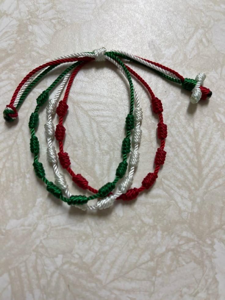 three string bracelets with red, green and white beads